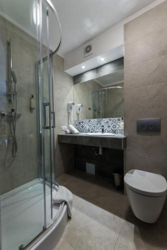 a bathroom with a shower and a toilet and a sink at Hotel Beskidzki Raj Medical SPA in Stryszawa