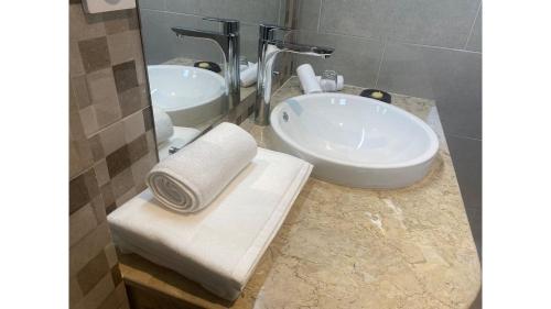 a bathroom with a white sink and a mirror at FLY INN Madagascar HOTEL - Navette GRATUITE H24 - à 300m de l'Aéroport International Ivato-Antananarivo in Ivato