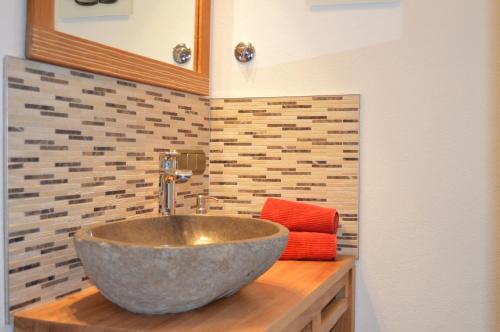 uma casa de banho com um lavatório num balcão de madeira em Am Sonneneck - Wohnung 7 em Ruhpolding