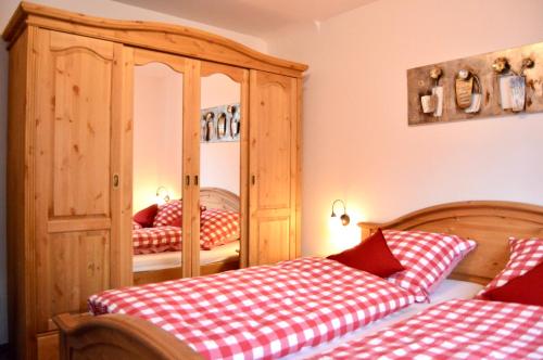 um quarto com 2 camas e um armário de madeira em Am Sonneneck - Wohnung 7 em Ruhpolding