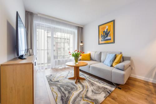 uma sala de estar com um sofá e uma mesa em Apartamenty Sun&Snow Osiedle Bursztynowe em Kolobrzeg