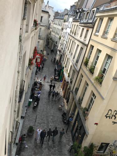 Un groupe de personnes marchant dans une rue avec des bâtiments dans l'établissement Rosiers, à Paris