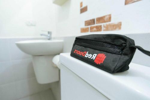 eine schwarze Tasche auf einer Theke im Bad in der Unterkunft RedDoorz Syariah @ Hotel Kencana Tasikmalaya in Tasikmalaya
