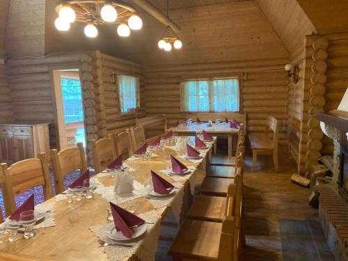 uma grande sala de jantar com mesas longas e cadeiras em Druzhba Hotel em Uzhhorod