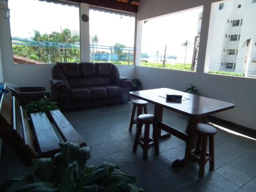 sala de estar con mesa y sofá en Recanto Casa de Pedrinha - Aptos para temporada e finais de semana, en Caraguatatuba