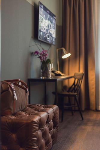 a living room with a couch and a desk with a computer at Best Western Plus Hus 57 in Ängelholm