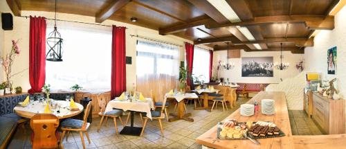 a restaurant with tables and chairs in a room at Heinrichshof in Mühlbach am Hochkönig