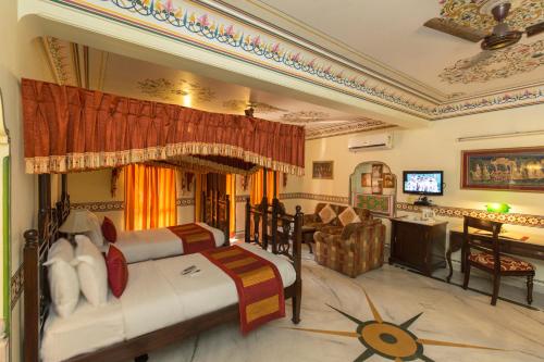 a bedroom with two beds and a living room at Umaid Bhawan - A Heritage Style Boutique Hotel in Jaipur