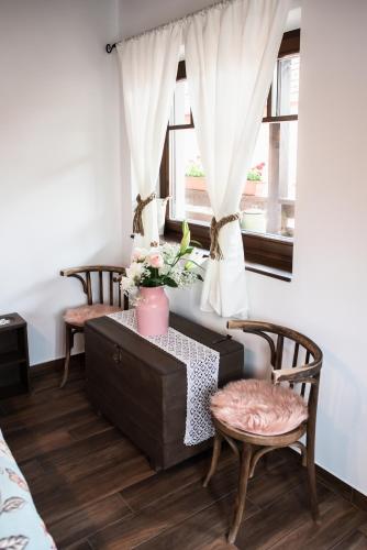 a room with a table and two chairs and a window at Boróka Vendégház Tóalmás in Tóalmás