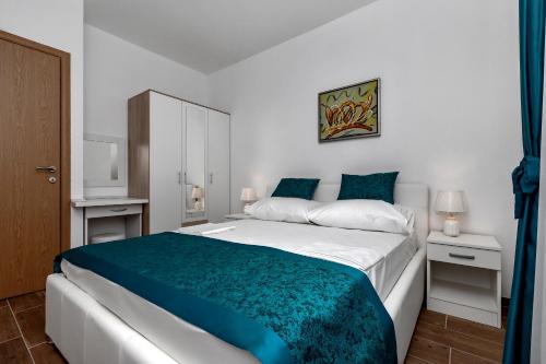 1 dormitorio con 1 cama grande con manta azul en Apartments Villa Medo, en Makarska