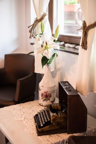 a flower in a vase sitting on top of a table at Boróka Vendégház Tóalmás in Tóalmás