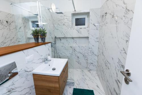 a white bathroom with a sink and a mirror at Colorful & Cozy Condo in Cluj-Napoca