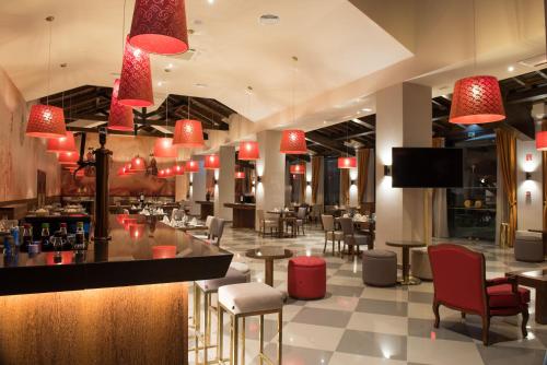 a restaurant with a bar and tables and chairs at Vila Gale Collection Alter Real - Resort Equestre, Conference & Spa in Alter do Chão