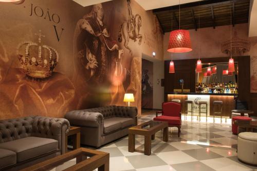 a living room with couches and a bar at Vila Gale Collection Alter Real - Resort Equestre, Conference & Spa in Alter do Chão