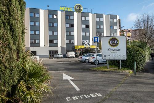 a sign in a parking lot in front of a hotel at B&B HOTEL Toulouse Centre Canal du Midi in Toulouse