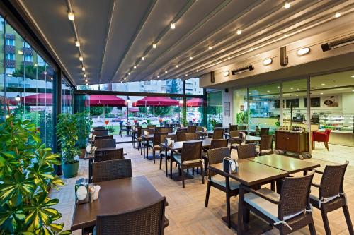 a restaurant with tables and chairs and windows at The Room Hotel & Apartments in Antalya