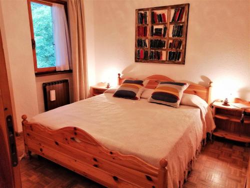 1 dormitorio con 1 cama de madera y 2 almohadas en House L’amour dans les Montagnes by Holiday World, en Morgex