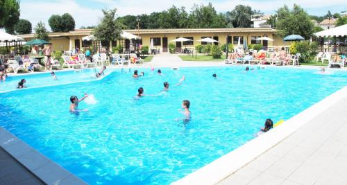 people are swimming in a pool at Koko Hotel in Milano Marittima