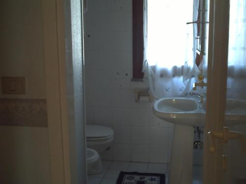 een badkamer met een wastafel en een toilet bij Villetta La Ginestra in Stintino