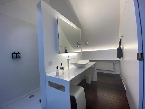 a white bathroom with a sink and a mirror at B&B Villa Tartine in Puurs