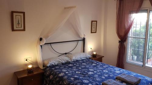 ein Schlafzimmer mit einem blauen Bett und einem Fenster in der Unterkunft Vera Rental Thalassa IV in Vera