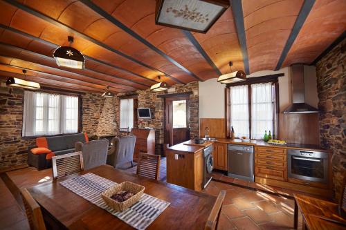 a kitchen with a wooden ceiling and a wooden table at La Quintana de Somao, Casa Quintana in Somado