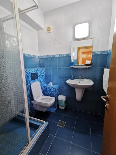 a blue bathroom with a toilet and a sink at Vila Gente in Mamaia Sat/Năvodari