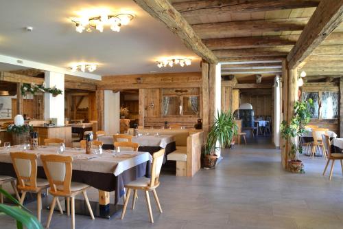 a restaurant with wooden ceilings and tables and chairs at Agritur Scoiattolo in Coredo