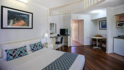 a hotel room with a bed and a kitchen at Toowong Central Motel Apartments in Brisbane