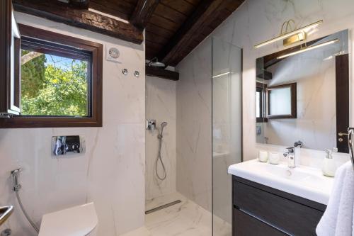 y baño con ducha y lavamanos. en Villa Ionica, en Kontokali