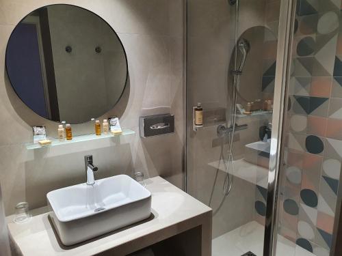 a bathroom with a sink and a shower at Mercure Villeneuve Loubet Plage in Villeneuve-Loubet