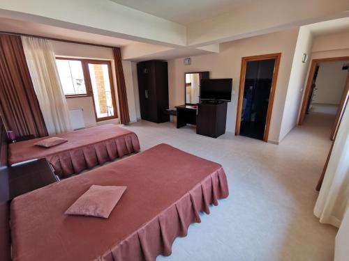 a hotel room with two beds and a television at Vila Gente in Mamaia Nord