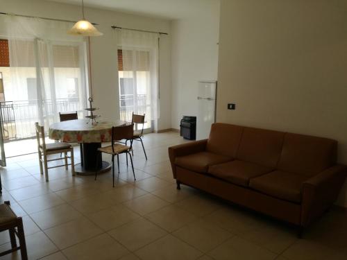 un soggiorno con divano, tavolo e sedie di Appartamento a Villapiana Lido a Villapiana