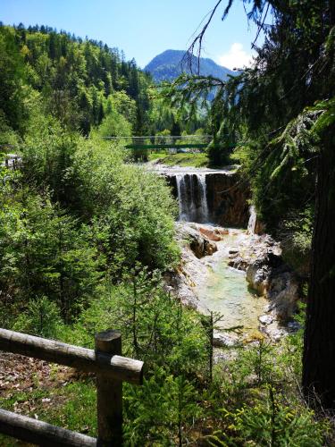 a waterfall in the middle of a river with a fence at Apartma Lucijana in Mojstrana