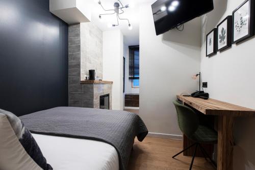 a bedroom with a bed and a desk and a television at Quentin Amsterdam Hotel in Amsterdam