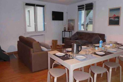 un salon avec une table et un canapé dans l'établissement Cauterets coeur village grand duplex 11 couchages, à Cauterets