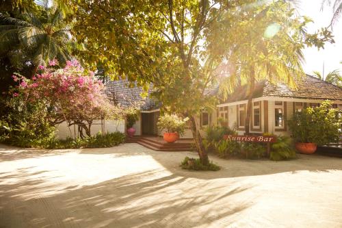 a house with trees and flowers in front of it at Sun Siyam Olhuveli in South Male Atoll
