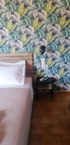 a cat sitting on a chair in a bedroom with a wallpaper at Stalis Drops in Stalida
