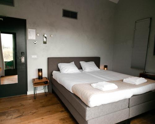 a bedroom with a large bed with white sheets at "Het Wapen Van Willemstad" in Willemstad