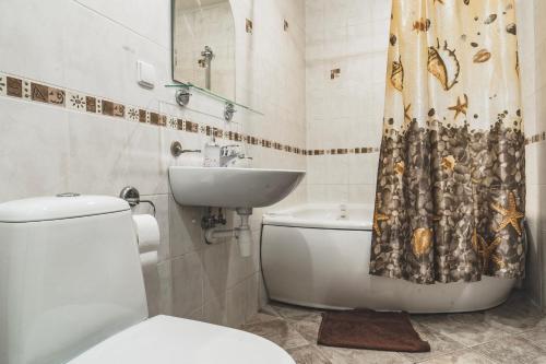 een badkamer met een toilet, een wastafel en een douchegordijn bij Old City Apartments in Rīga