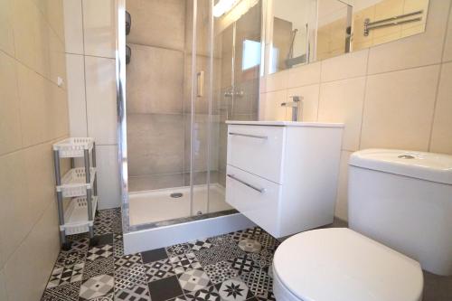 ein Bad mit einem WC und einer Glasdusche in der Unterkunft Przytulne mieszkanie w Sopocie in Sopot