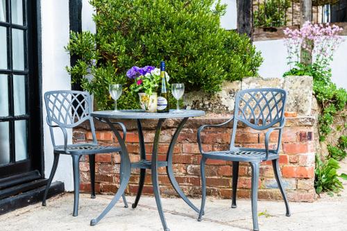 a table and two chairs with wine glasses and flowers at The Old Farm in Gloucester