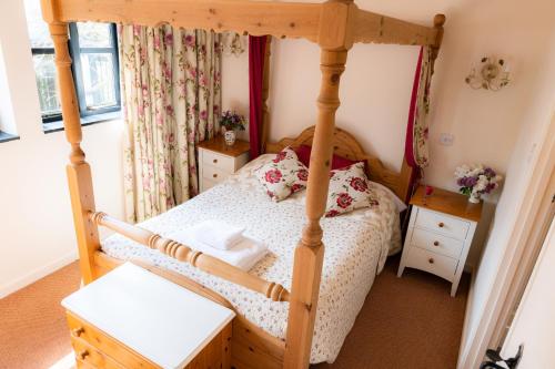 a bedroom with a four poster bed and flowers at The Old Farm in Gloucester