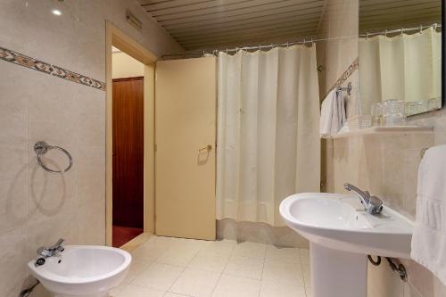a bathroom with a sink, toilet and shower at Residencial Horizonte in Lisbon