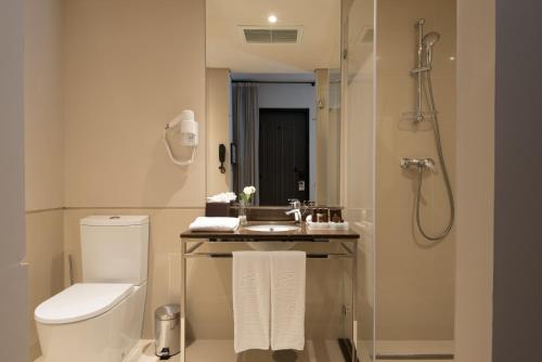 a bathroom with a toilet and a sink and a shower at Vila Gale Collection Alter Real - Resort Equestre, Conference & Spa in Alter do Chão