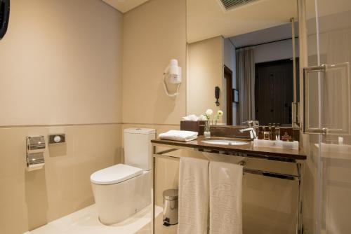 a bathroom with a toilet and a sink and a mirror at Vila Gale Collection Alter Real - Resort Equestre, Conference & Spa in Alter do Chão