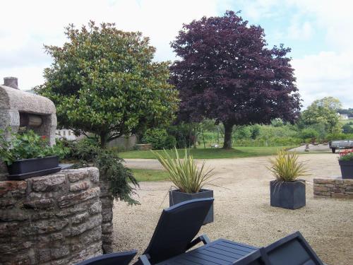a patio with a table and chairs and plants at longère de kervéguen ARGOAT in Leuhan