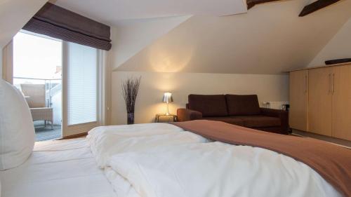 a bedroom with a bed and a chair and a window at Best Western Hotel Herman Bang in Frederikshavn