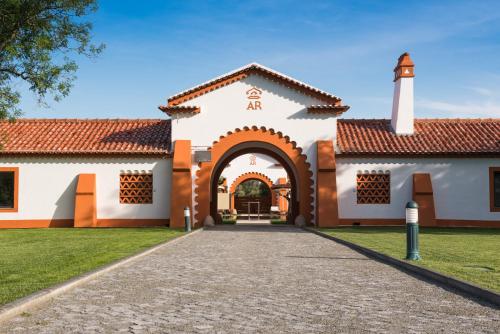 an exterior view of a building with an archway at Vila Gale Collection Alter Real - Resort Equestre, Conference & Spa in Alter do Chão