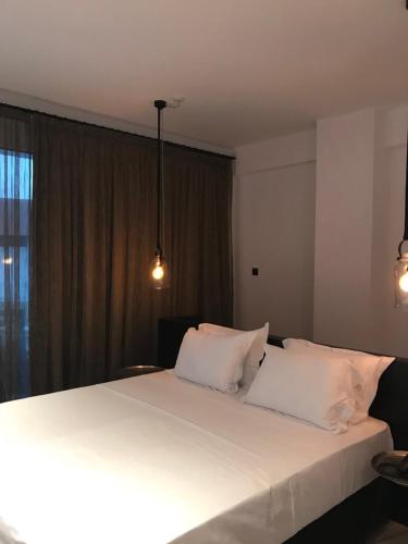a bedroom with a large white bed with two pillows at Abacus Suites in Ayia Napa